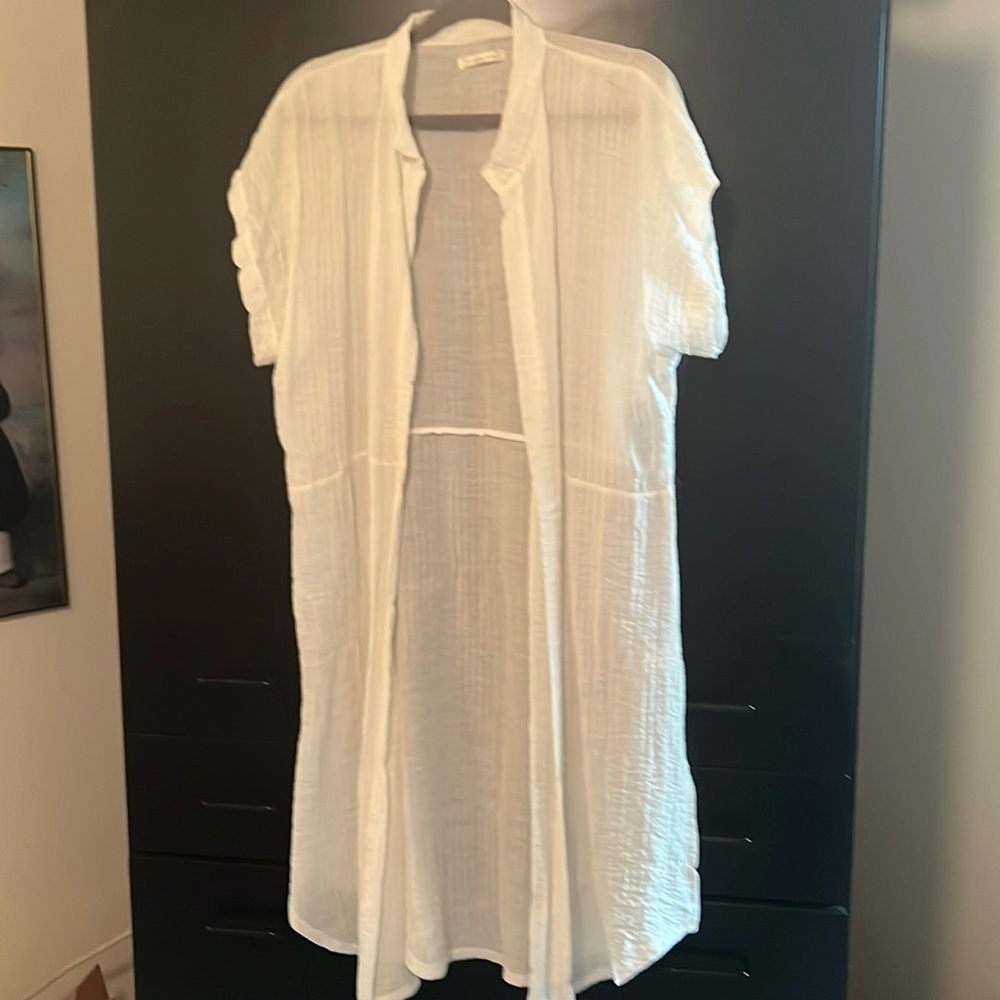 Long duster. White, short-sleeved. 100% polyester and but feels like gauze.